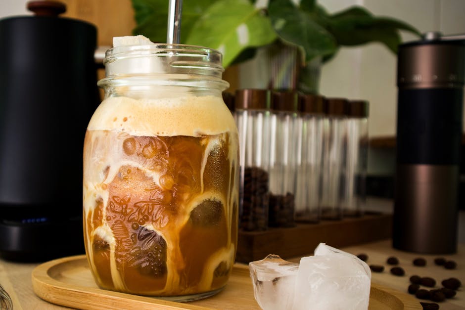 Cold brew coffee served in a mason jar with a straw on a wooden tray