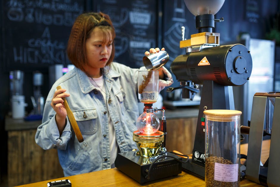 Barista preparing coffee with a siphon brewer in a cozy cafe